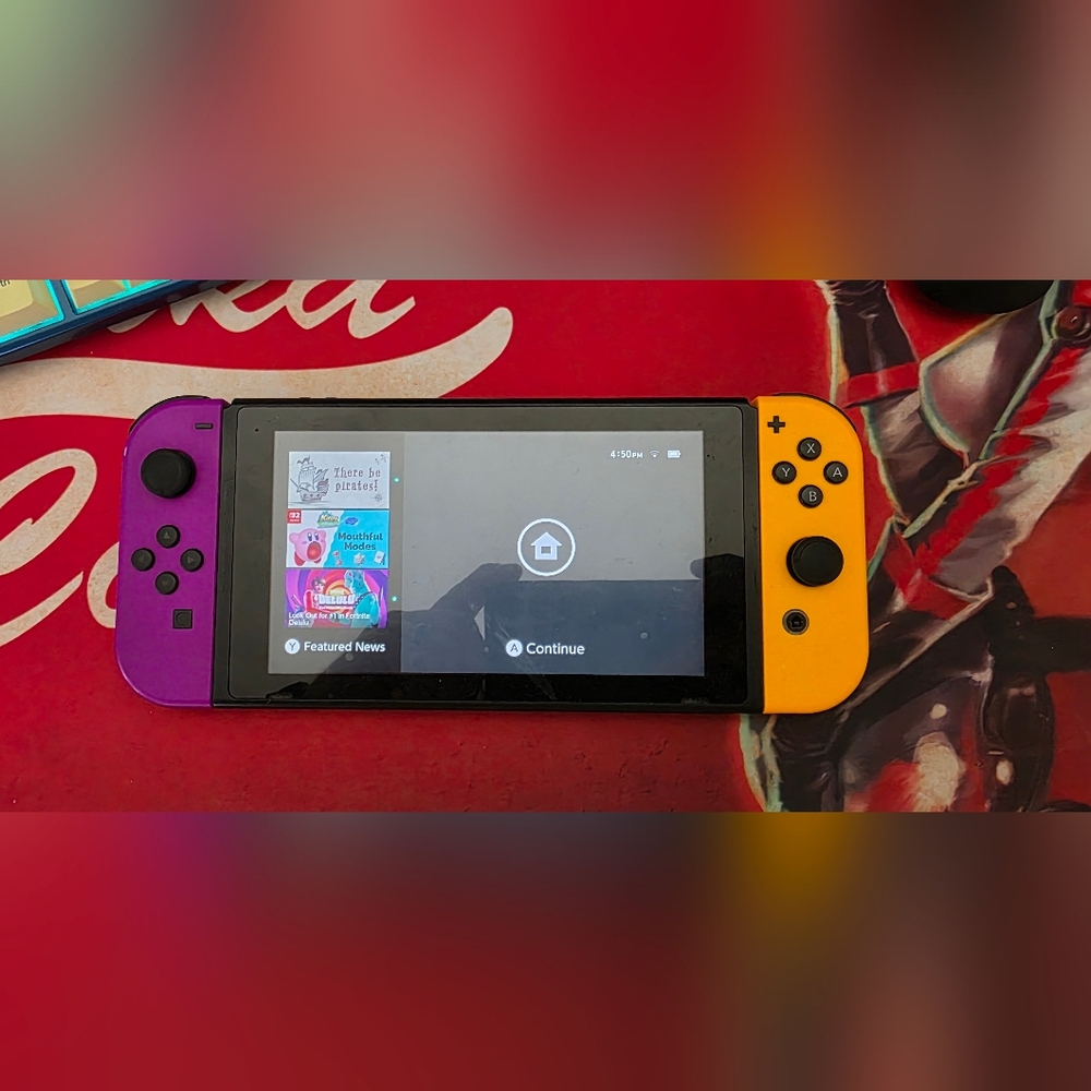 Handheld Gaming Console with Purple and Yellow Controllers